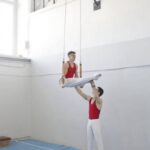 Training - Men in White Pants Red Jersey Near Wall