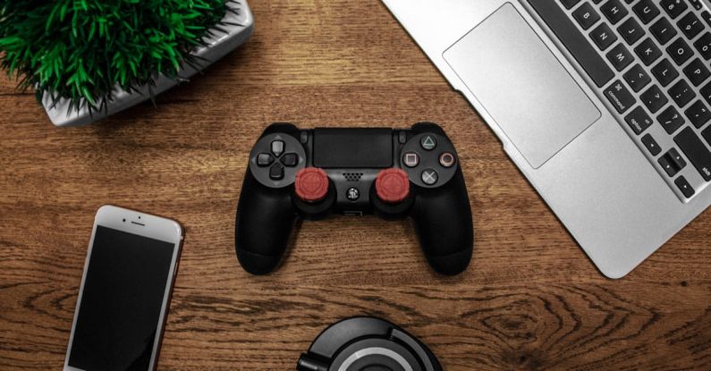 Gadgets - Black Game Console on Wooden Surface