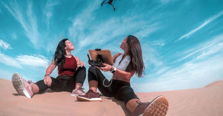 Gadgets - Two Woman Sitting On Sand While Playing Drone