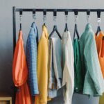 Outfits - Clothes on Black Metal Rack with Pairs of Footwear on Floor