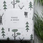 Gift - Wrapped New Year present box placed among coniferous branches